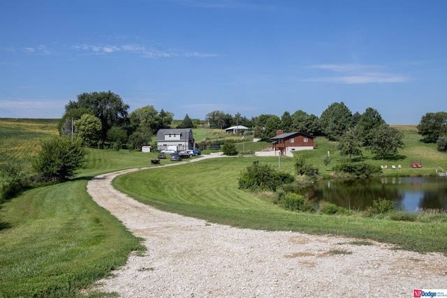 view of property's community with a water view and a lawn