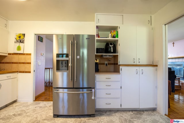 kitchen with light parquet floors, white cabinetry, and stainless steel fridge with ice dispenser