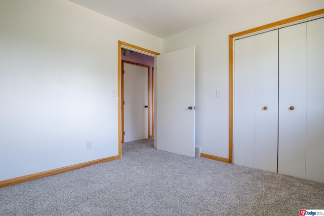 unfurnished bedroom featuring carpet and a closet