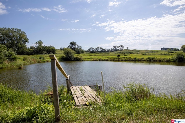 view of dock with a rural view and a water view