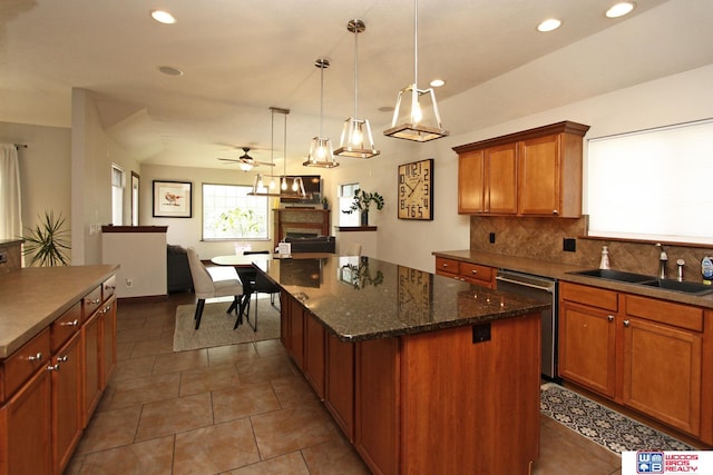 kitchen featuring sink, dark tile patterned floors, dishwasher, and a kitchen island