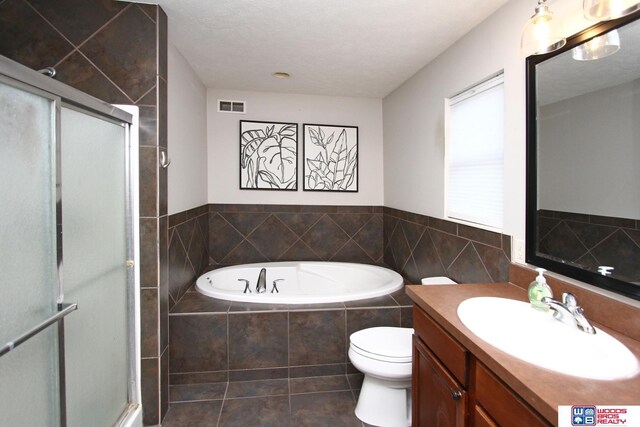 full bathroom with vanity, independent shower and bath, toilet, a textured ceiling, and tile patterned flooring