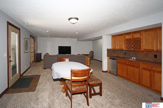 carpeted dining area with sink and a textured ceiling