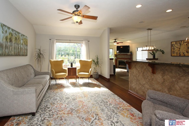 living room featuring lofted ceiling, dark hardwood / wood-style flooring, and ceiling fan