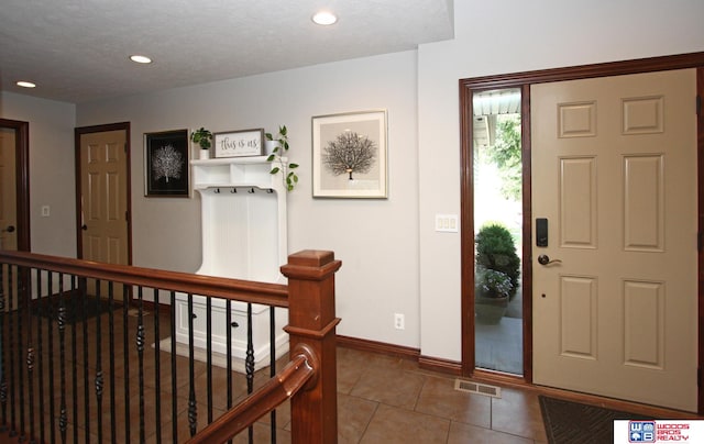 foyer featuring tile patterned flooring and a textured ceiling