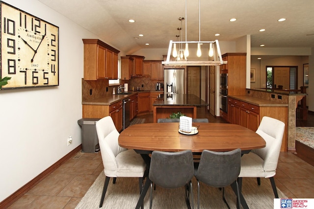 dining area with sink, tile patterned flooring, and lofted ceiling