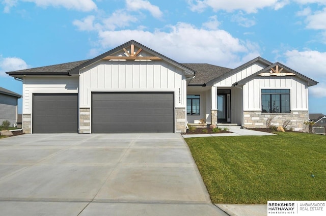 modern inspired farmhouse featuring a garage, driveway, roof with shingles, board and batten siding, and a front yard