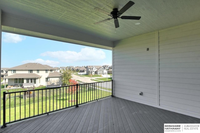 wooden deck featuring ceiling fan and a lawn