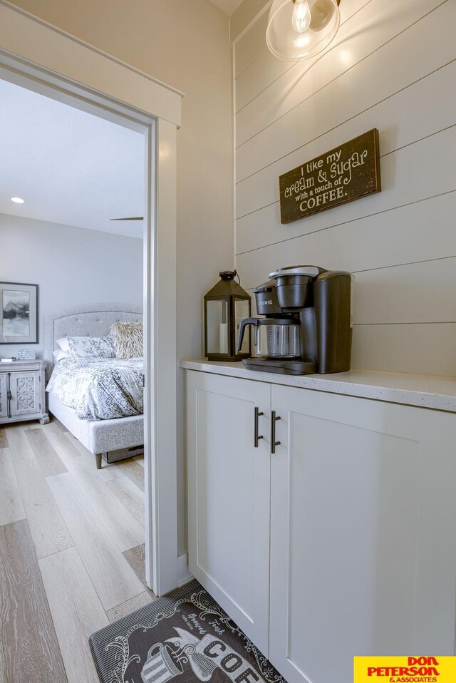 laundry area with light hardwood / wood-style floors, cabinets, and washing machine and clothes dryer