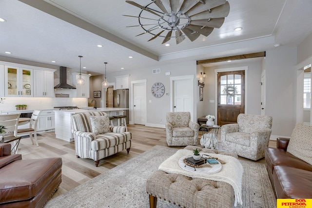 living room featuring light hardwood / wood-style floors and a raised ceiling