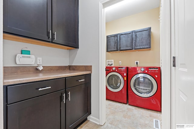 laundry area with cabinets, washing machine and dryer, and light tile patterned floors