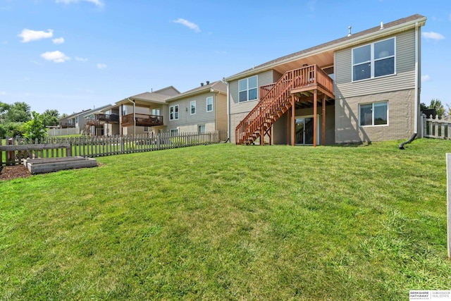 rear view of house with a deck and a yard