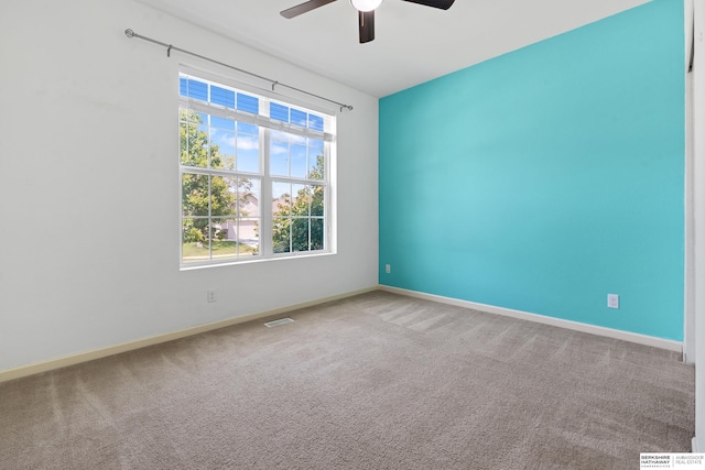 carpeted spare room featuring ceiling fan