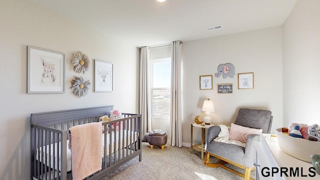 bedroom featuring a nursery area and light colored carpet