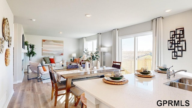 dining room with sink and light hardwood / wood-style flooring