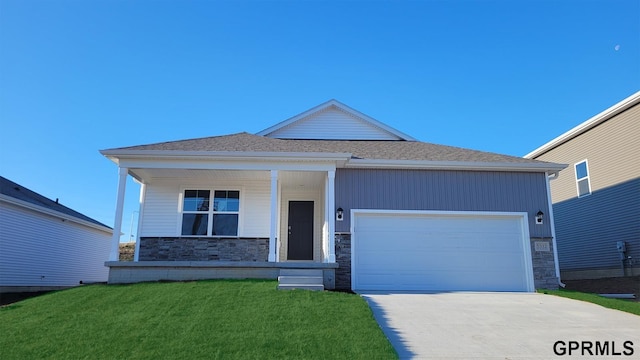 view of front facade with covered porch, a front yard, and a garage