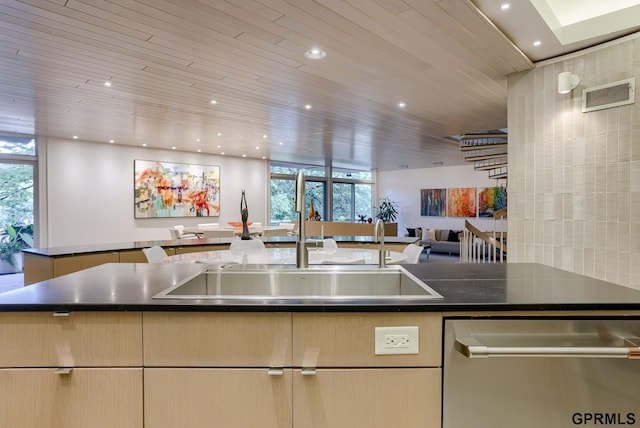 kitchen featuring sink, light brown cabinets, stainless steel dishwasher, and a healthy amount of sunlight