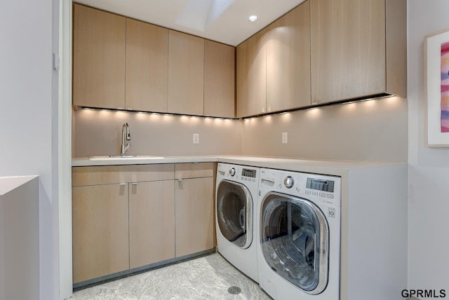 laundry room featuring washing machine and dryer, sink, and cabinets