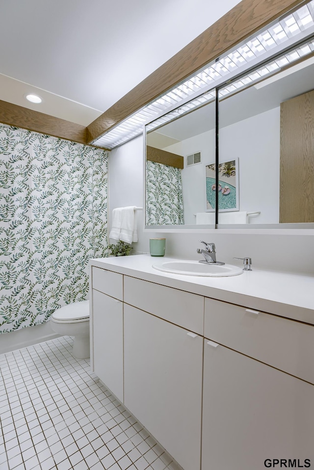 bathroom with toilet, tile patterned floors, and vanity