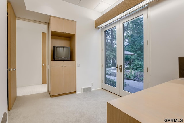 bedroom featuring light carpet, french doors, and access to exterior