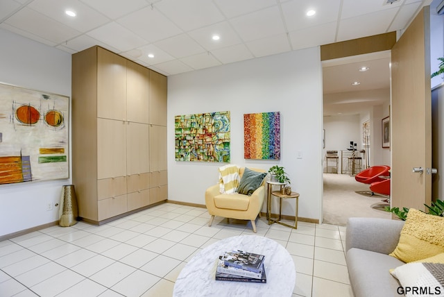 sitting room with a drop ceiling and light colored carpet