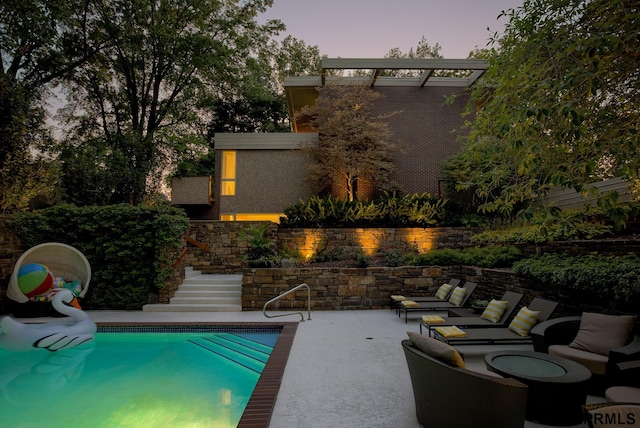 pool at dusk featuring a patio