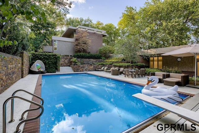 view of pool featuring a diving board and a patio