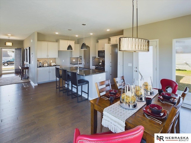 dining area with sink, a wealth of natural light, and dark hardwood / wood-style floors