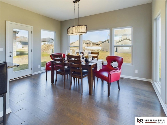 dining space featuring dark wood-style floors and baseboards