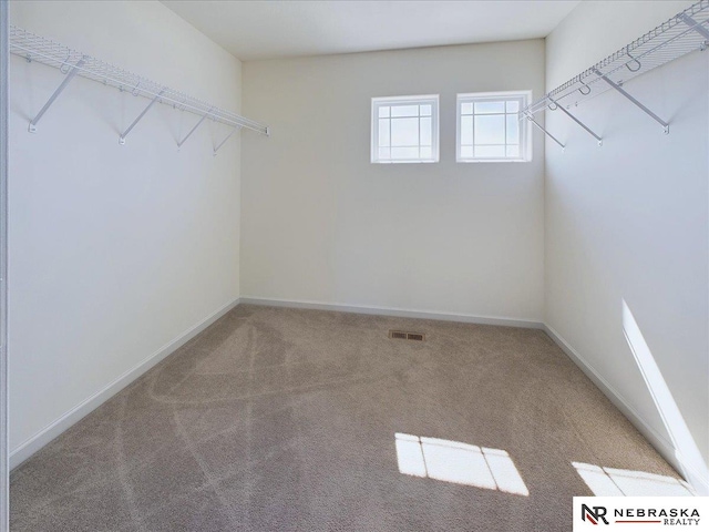 walk in closet featuring visible vents and carpet