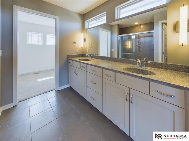 bathroom featuring a wealth of natural light, tile patterned flooring, and double vanity