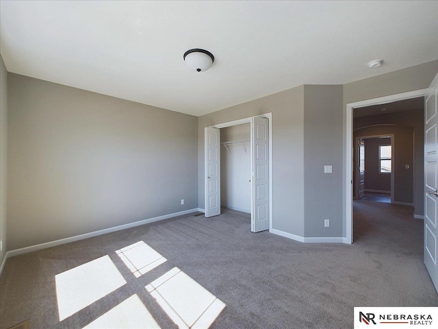 unfurnished bedroom featuring a closet, baseboards, and carpet floors