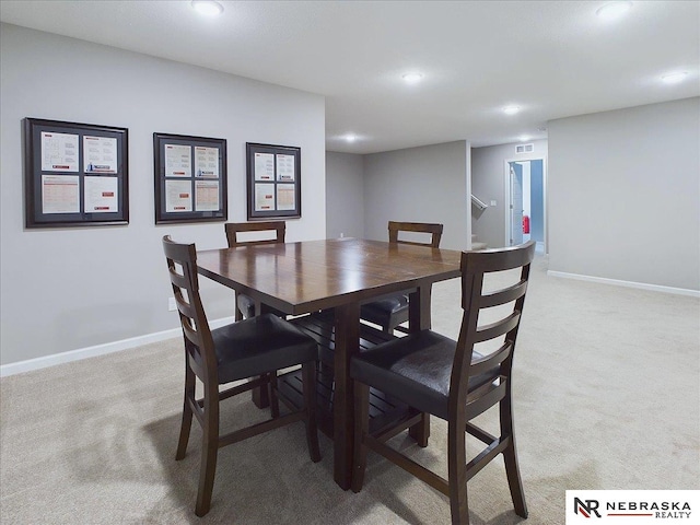 dining space featuring light carpet, baseboards, and visible vents