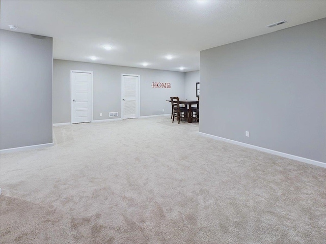 basement featuring baseboards, carpet, and visible vents