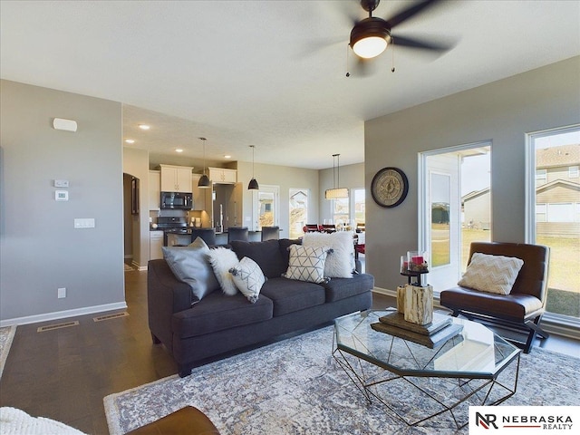 living area with visible vents, ceiling fan, baseboards, and dark wood-style floors
