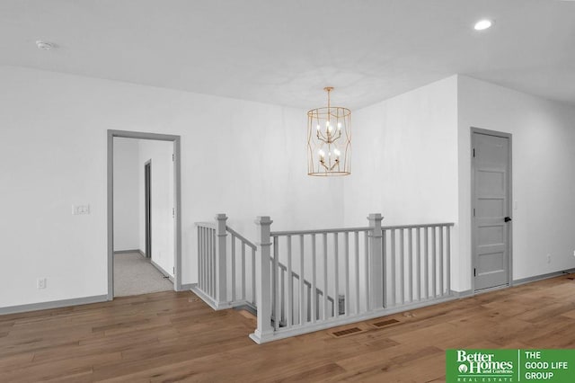 hallway with a chandelier and hardwood / wood-style flooring