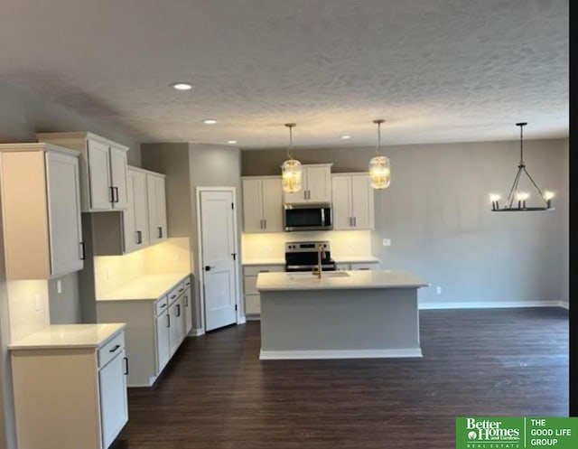 kitchen featuring white cabinetry, dark hardwood / wood-style flooring, decorative light fixtures, and appliances with stainless steel finishes