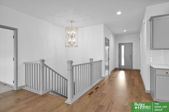 entryway with recessed lighting, a notable chandelier, light wood-style floors, and visible vents
