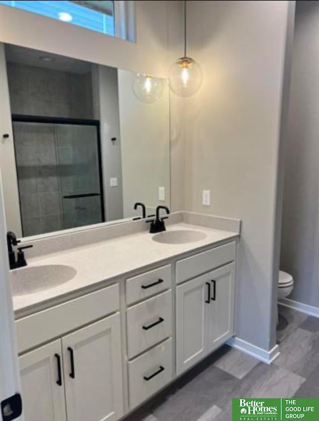 bathroom with vanity, toilet, and a shower with shower door