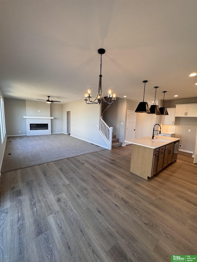 kitchen featuring pendant lighting, white cabinetry, dark hardwood / wood-style floors, and a kitchen island with sink