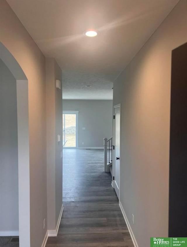 8701 N 177th St, Bennington, NE 68007 - hallway featuring dark wood-style floors, baseboards, recessed lighting, and arched walkways