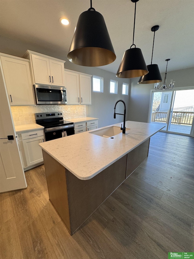 8701 N 177th St, Bennington, NE 68007 - kitchen featuring appliances with stainless steel finishes, a sink, a center island with sink, dark wood-style flooring, and white cabinetry