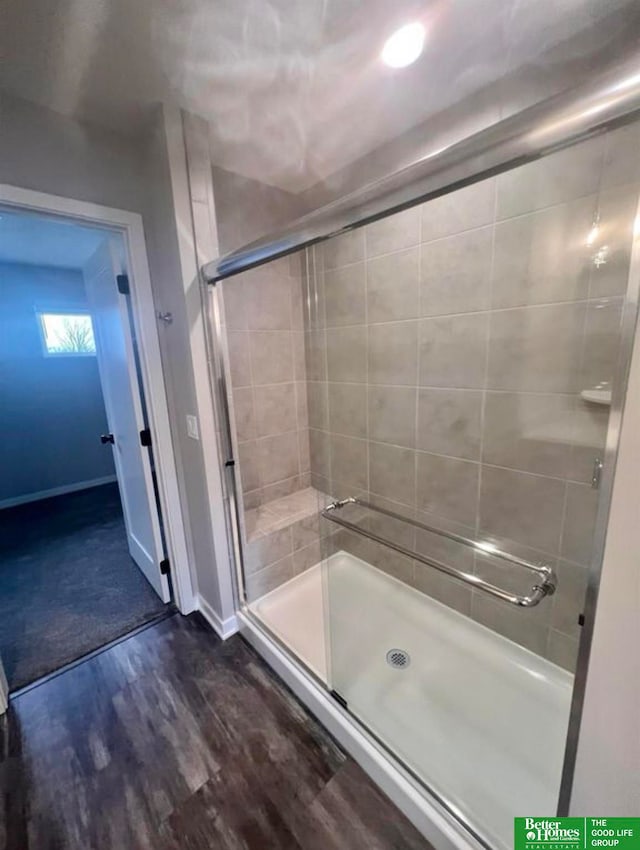 bathroom featuring wood-type flooring and a shower with shower door