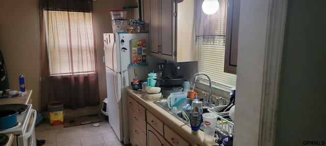 kitchen featuring sink, white refrigerator, and light tile patterned floors