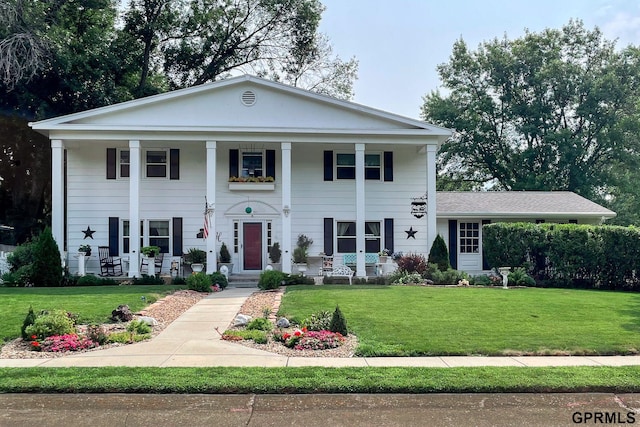 greek revival inspired property featuring a front yard