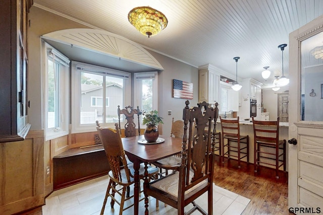 dining room with ornamental molding and light hardwood / wood-style floors