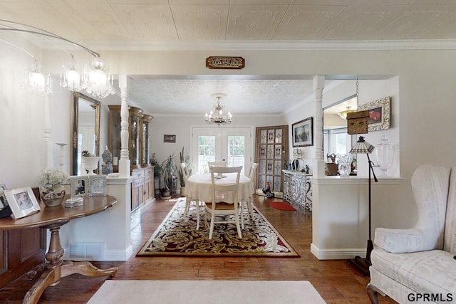 dining room with french doors, ornamental molding, decorative columns, and hardwood / wood-style flooring