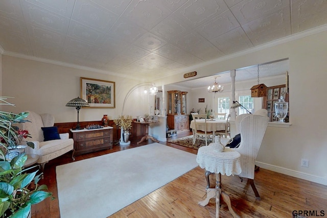 living room featuring light hardwood / wood-style flooring, a chandelier, and ornamental molding