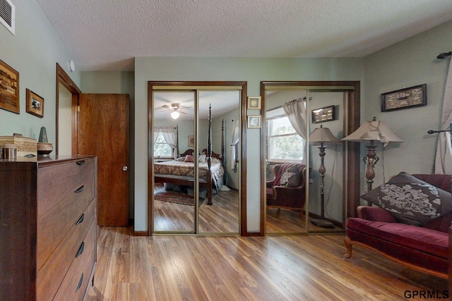 interior space featuring light hardwood / wood-style flooring, a textured ceiling, and multiple closets