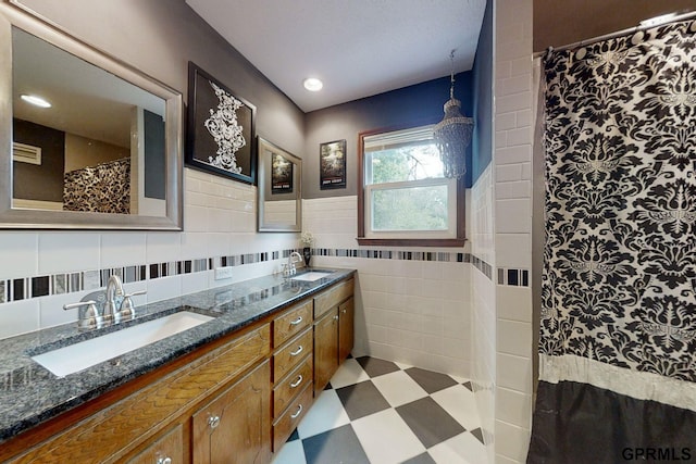 bathroom with double sink vanity, backsplash, tile walls, and tile patterned floors